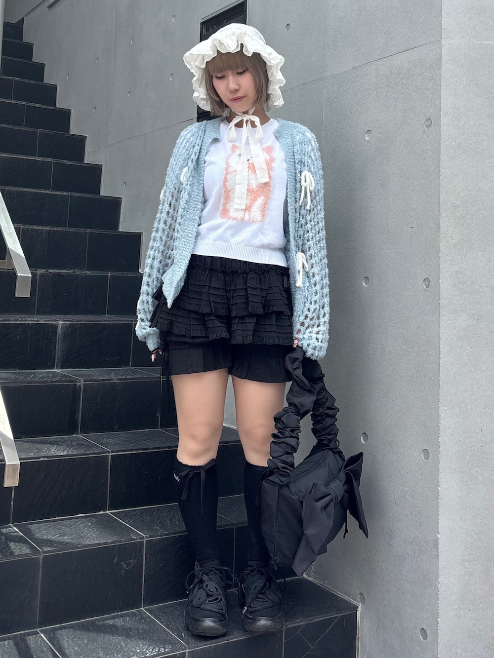 ブルー系のカーディガン/ボレロ、ホワイト系のニット/セーター、ブラック系のその他パンツを着用したレディースの夏コーディネートの4枚目の写真