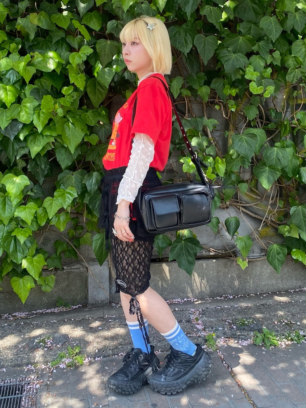 レッド系のTシャツ/カットソー、ホワイト系のその他トップス、ブラック系のスカートを着用したレディースの春コーディネートの2枚目の写真