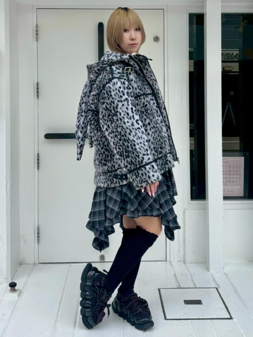 グレー系のダウンジャケット/コート、ブラック系のワンピース、グレー系のニット/セーターを着用したレディースの秋コーディネートの2枚目の写真