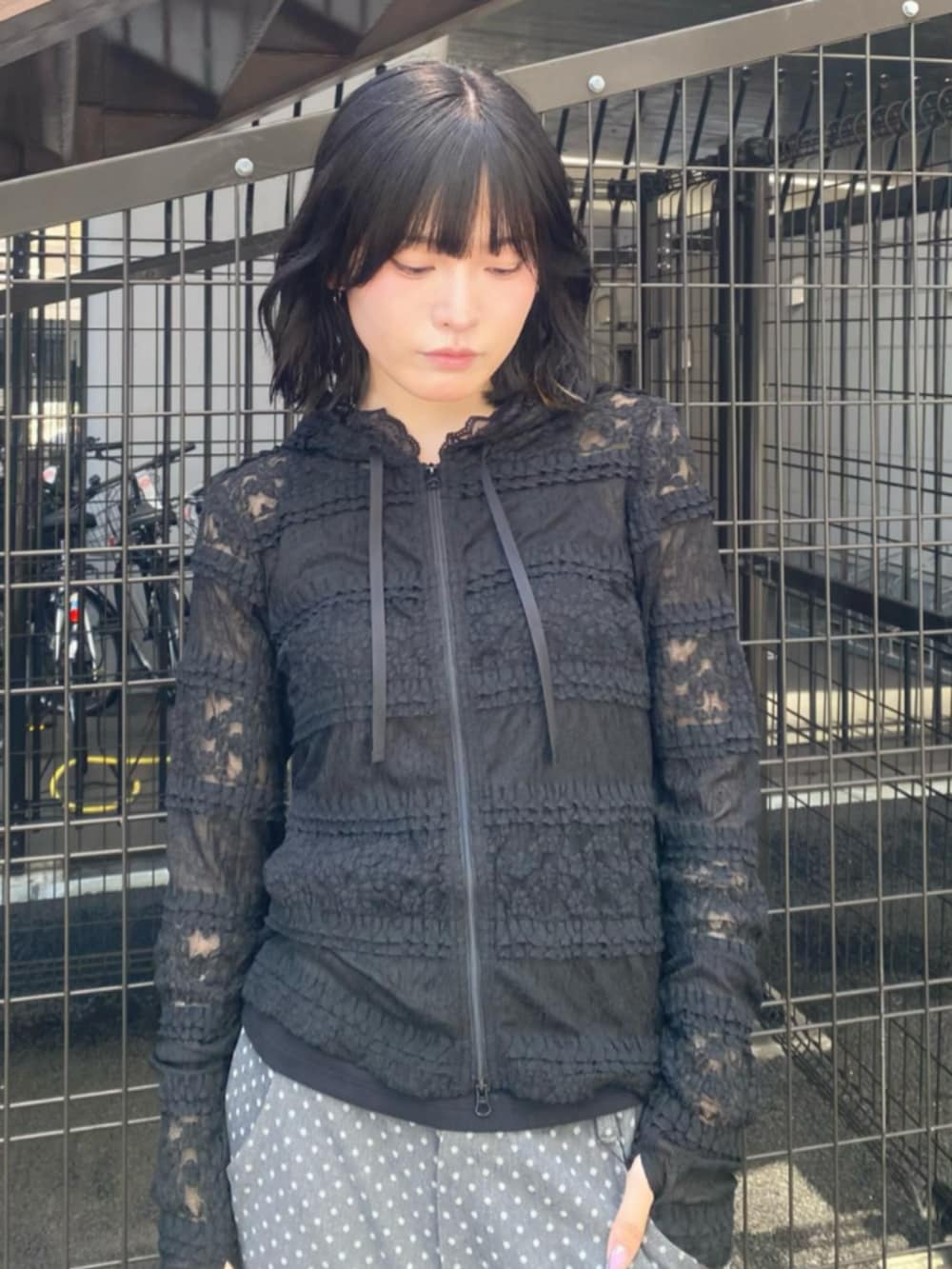 ブラック系のパーカー、ブラック系のショルダーバッグ、ブラック系のデニムパンツを着用したレディースの秋コーディネートの3枚目の写真