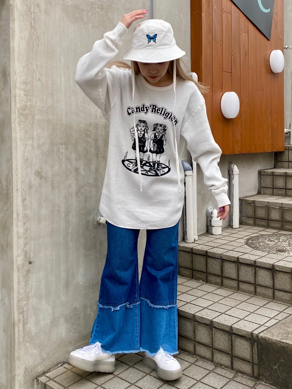 ブルー系のデニムパンツ、ホワイト系のTシャツ/カットソー、ホワイト系のハットを着用したレディースの冬コーディネートの2枚目の写真