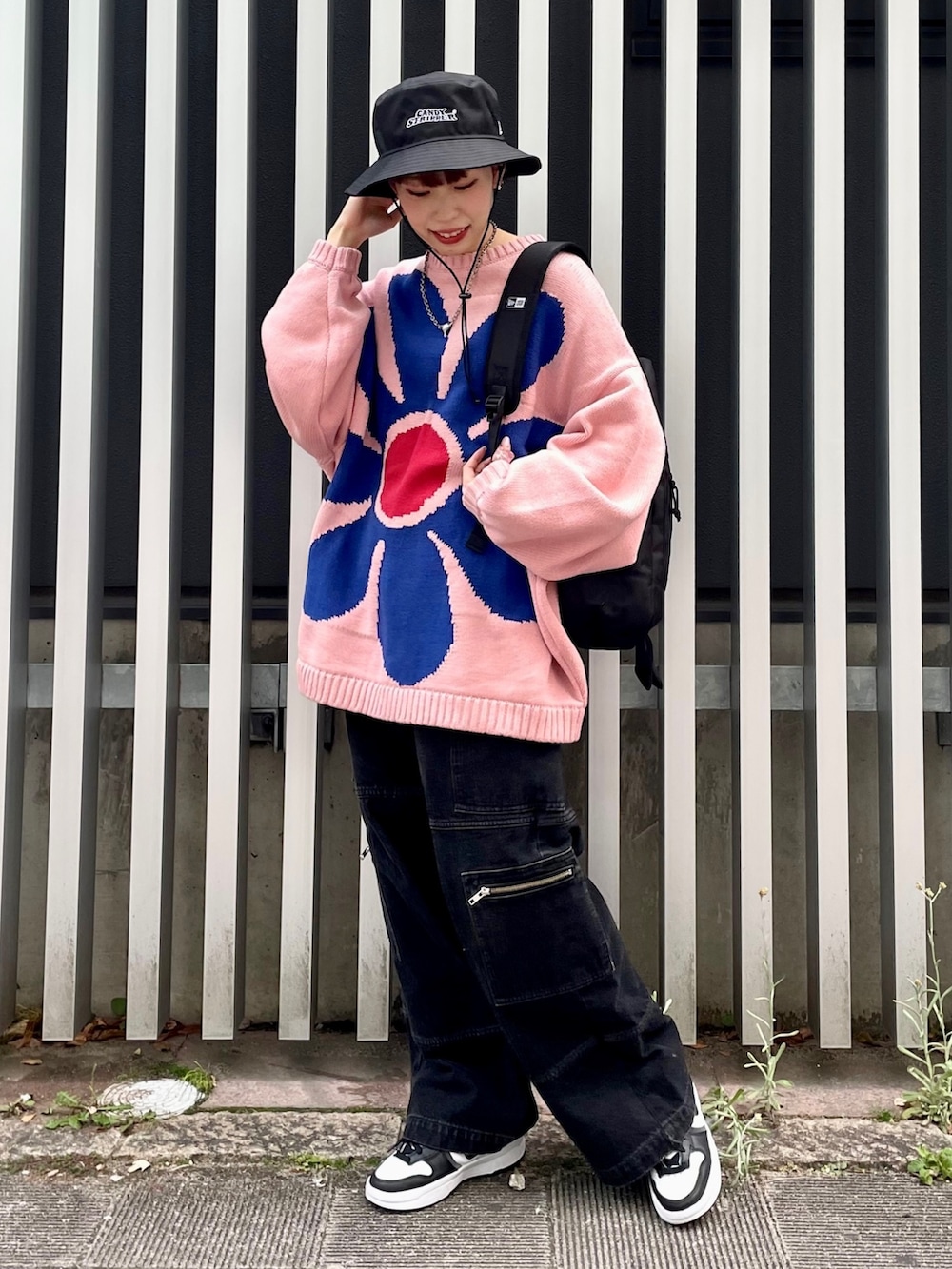 ブラック系のカーゴパンツ、ブラック系のバックパック/リュック、ピンク系のニット/セーターを着用したレディースの冬コーディネートの2枚目の写真