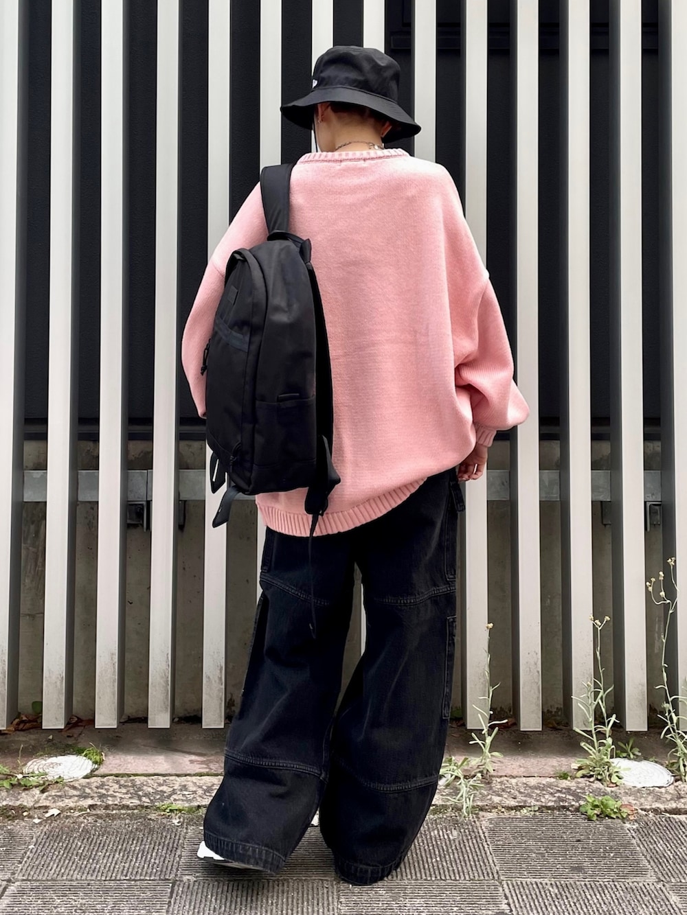 ブラック系のカーゴパンツ、ブラック系のバックパック/リュック、ピンク系のニット/セーターを着用したレディースの冬コーディネートの4枚目の写真