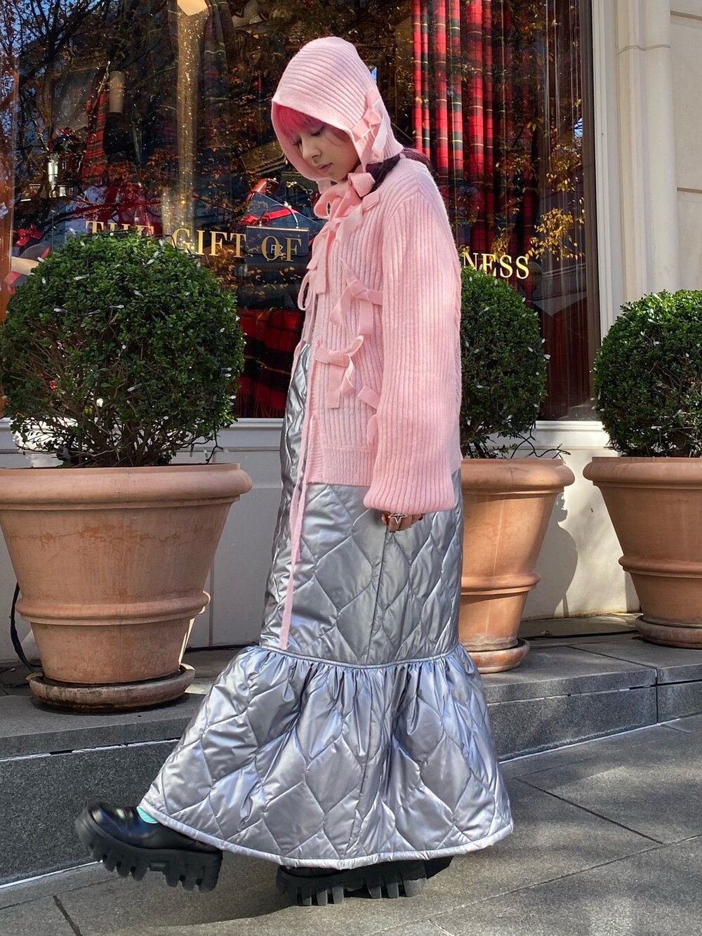 ピンク系のショルダーバッグ、シルバー系のワンピース、ピンク系のカーディガン/ボレロを着用したレディースの冬コーディネートの5枚目の写真