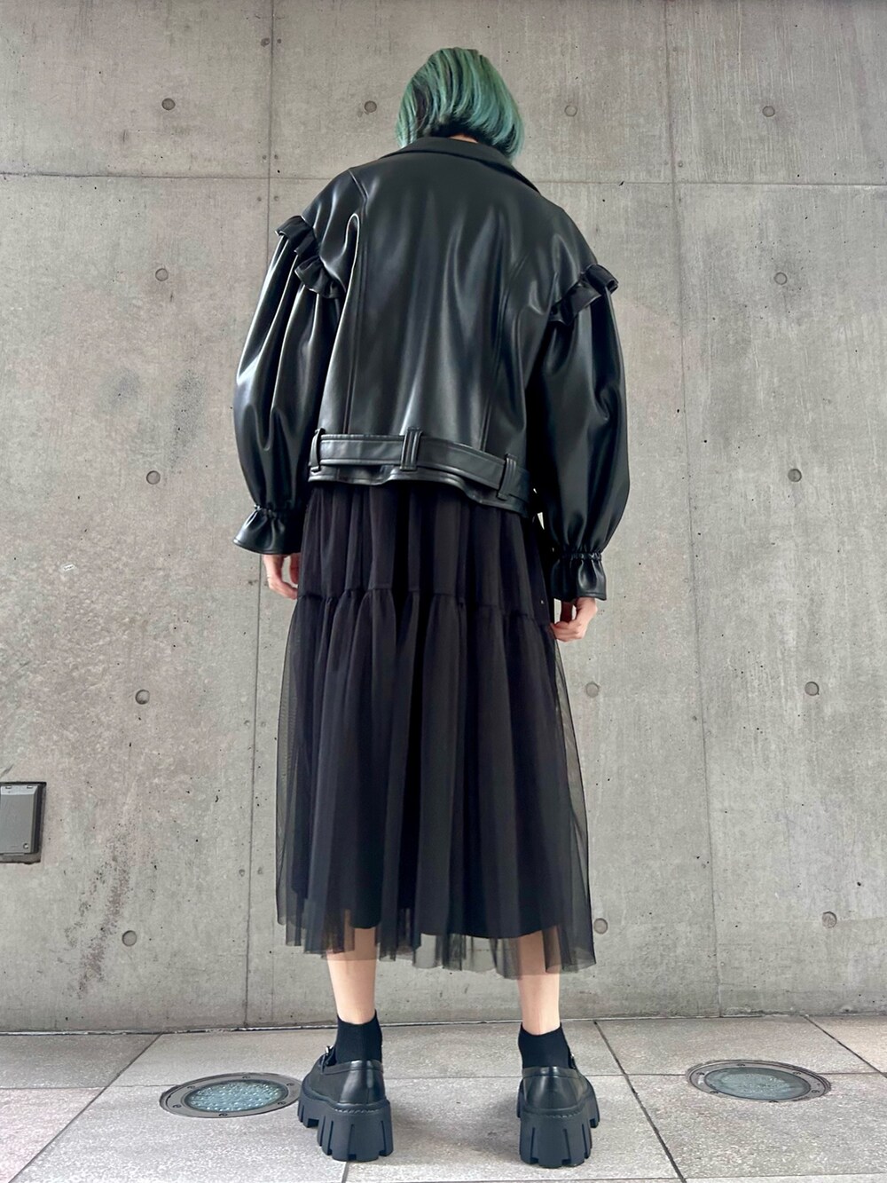 ブラック系のライダースジャケット、ブラック系のワンピース、ブラック系のローファーを着用したレディースの冬コーディネートの4枚目の写真