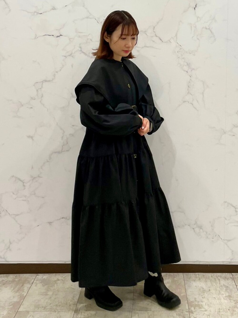 ブラック系のトレンチコート、ブラック系のブーツを着用したレディースの冬コーディネートの4枚目の写真