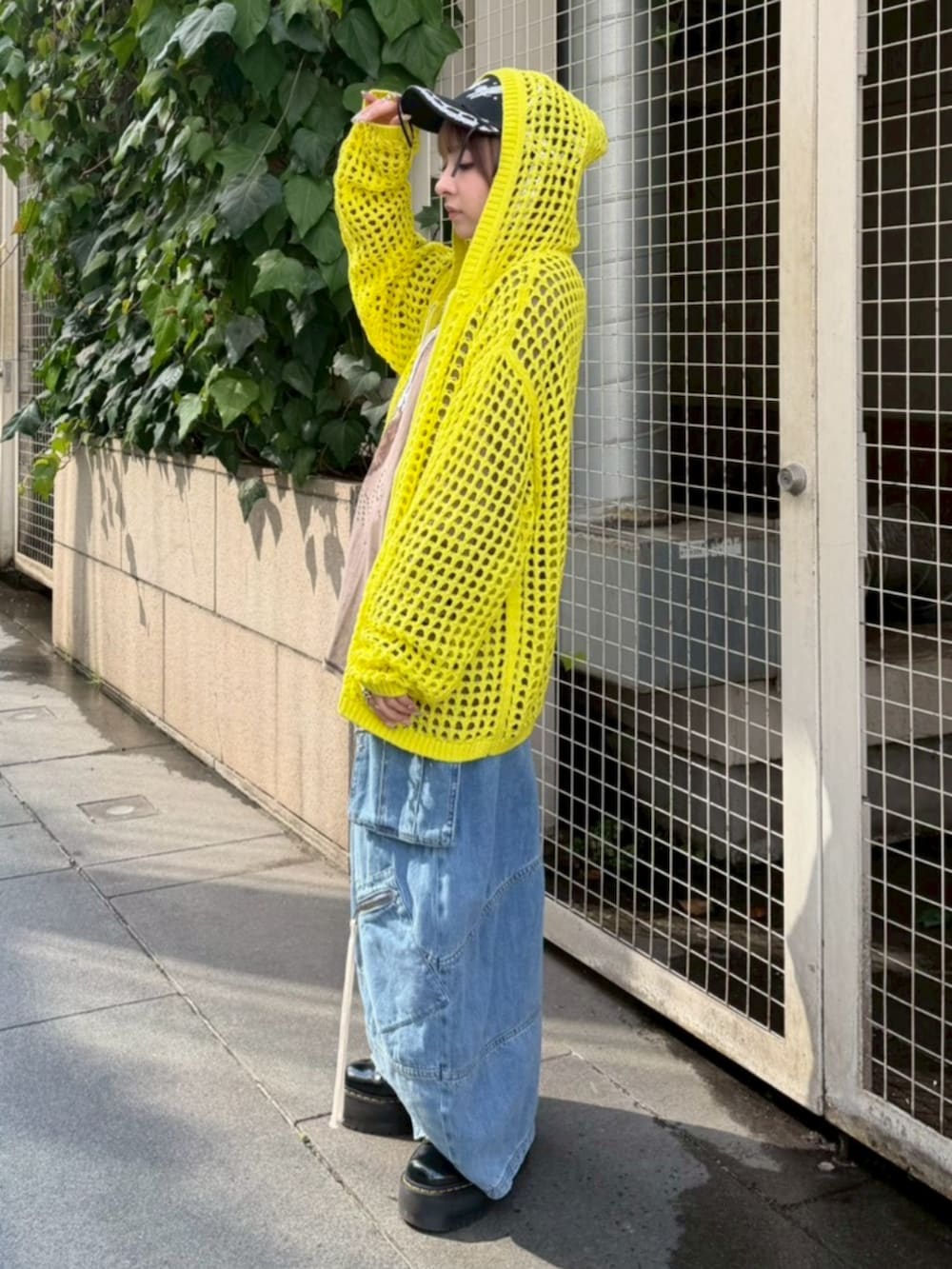 イエロー系のパーカー、ブラウン系のTシャツ/カットソー、ブルー系のデニムパンツを着用したレディースの春コーディネートの2枚目の写真