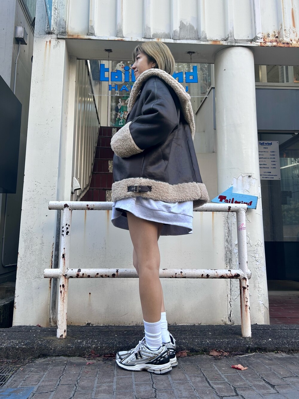 グレー系のスウェット、ブラック系のその他アウターを着用したレディースの冬コーディネートの3枚目の写真