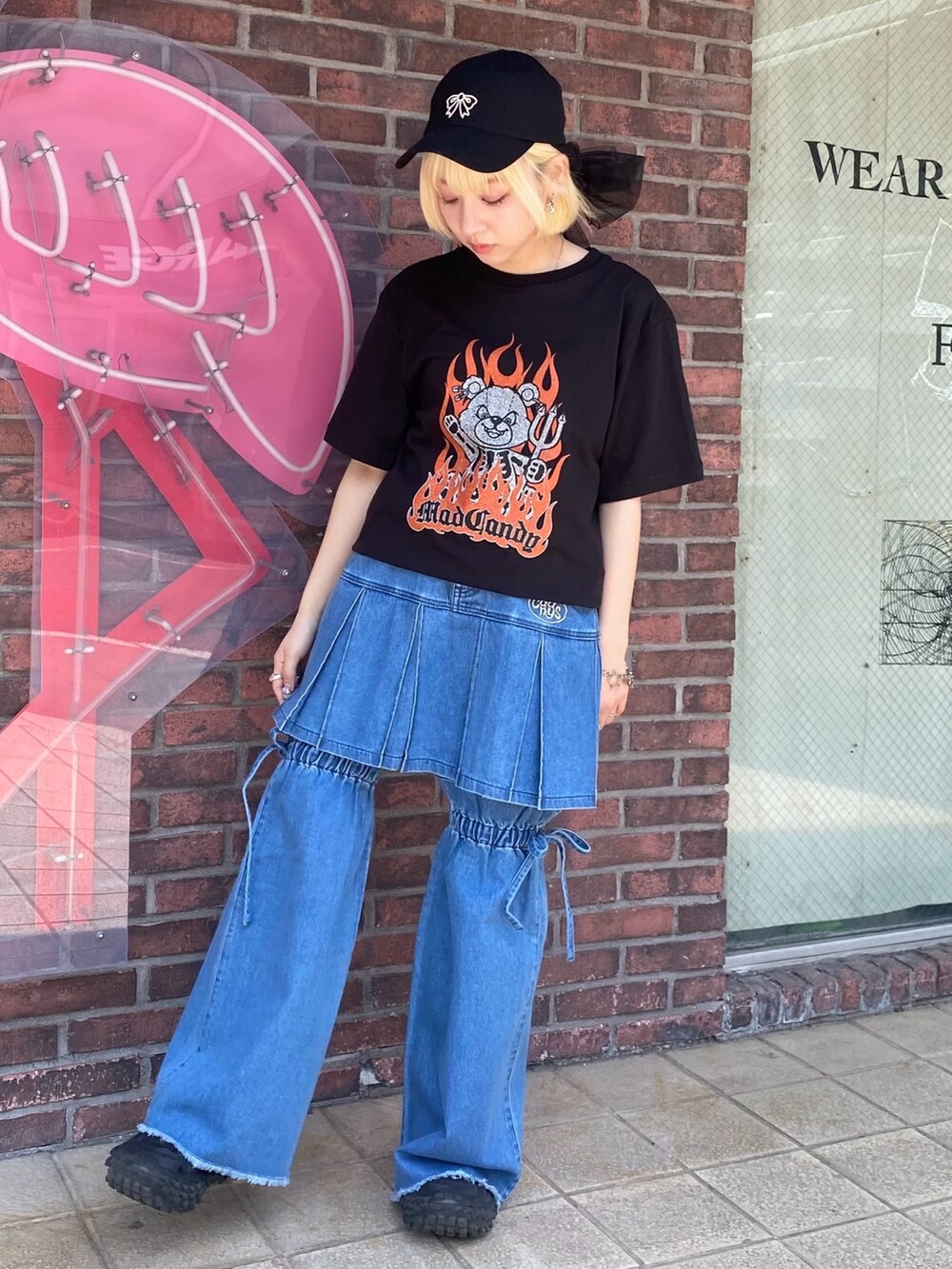 ブルー系のスカート、ブラック系のTシャツ/カットソー、ブラック系のキャップを着用したレディースの春コーディネートの3枚目の写真