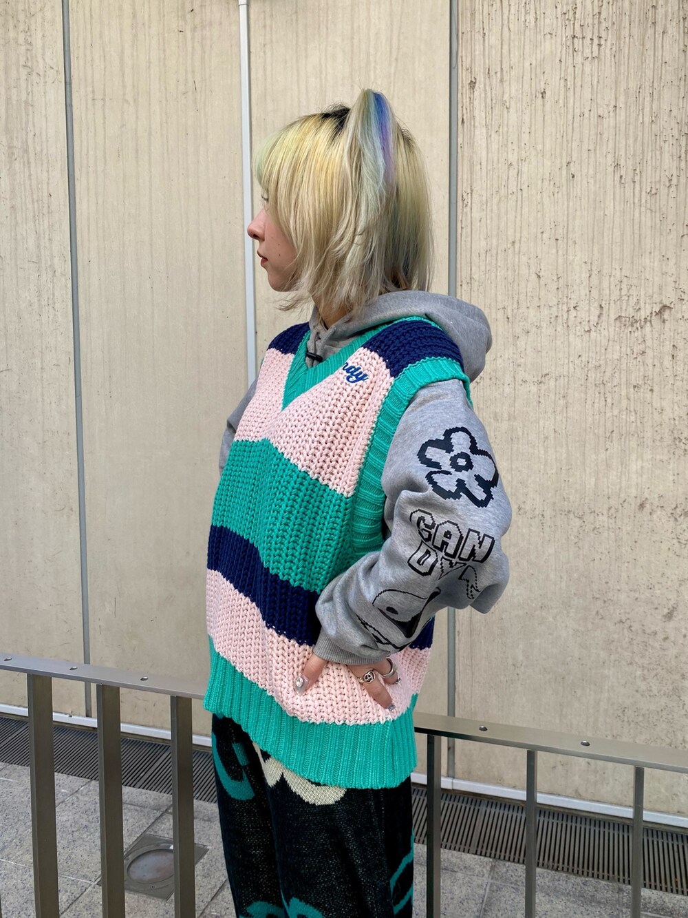 グレー系のパーカー、グリーン系のベスト、ブラック系のその他パンツを着用したレディースの冬コーディネートの5枚目の写真