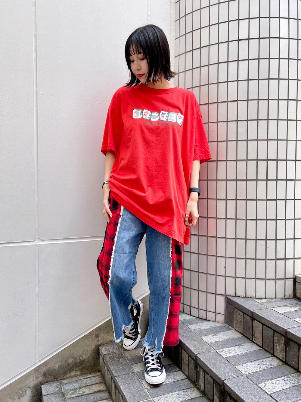 レッド系のTシャツ/カットソー、レッド系のデニムパンツ、ブラック系のスニーカーを着用したレディースの夏コーディネートの2枚目の写真