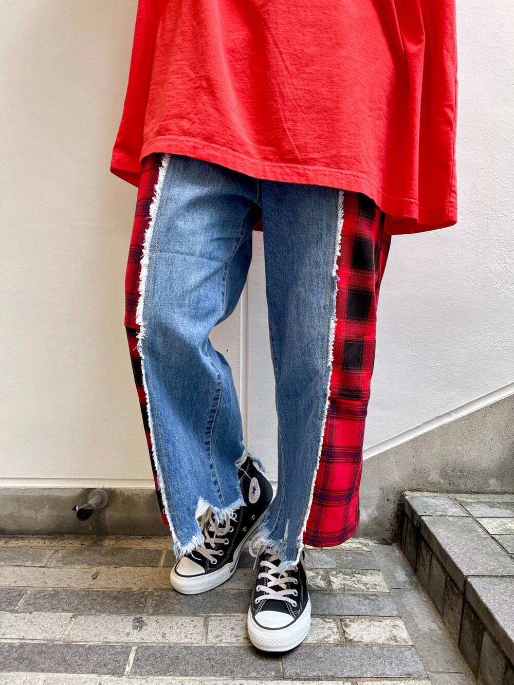 レッド系のTシャツ/カットソー、レッド系のデニムパンツ、ブラック系のスニーカーを着用したレディースの夏コーディネートの4枚目の写真