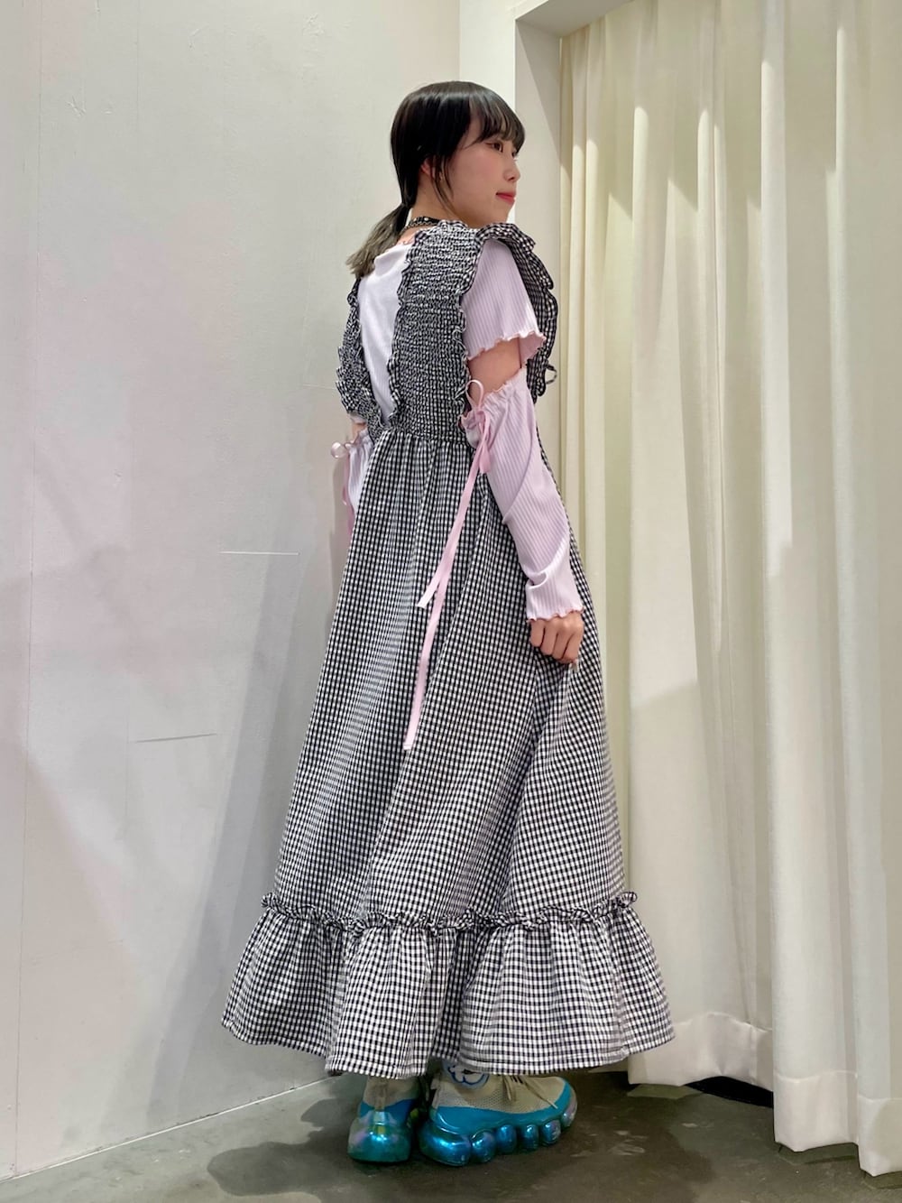 ピンク系のその他トップス、ホワイト系のジャンパースカート、ホワイト系のボディバッグ/ウエストポーチを着用したレディースの春コーディネートの3枚目の写真