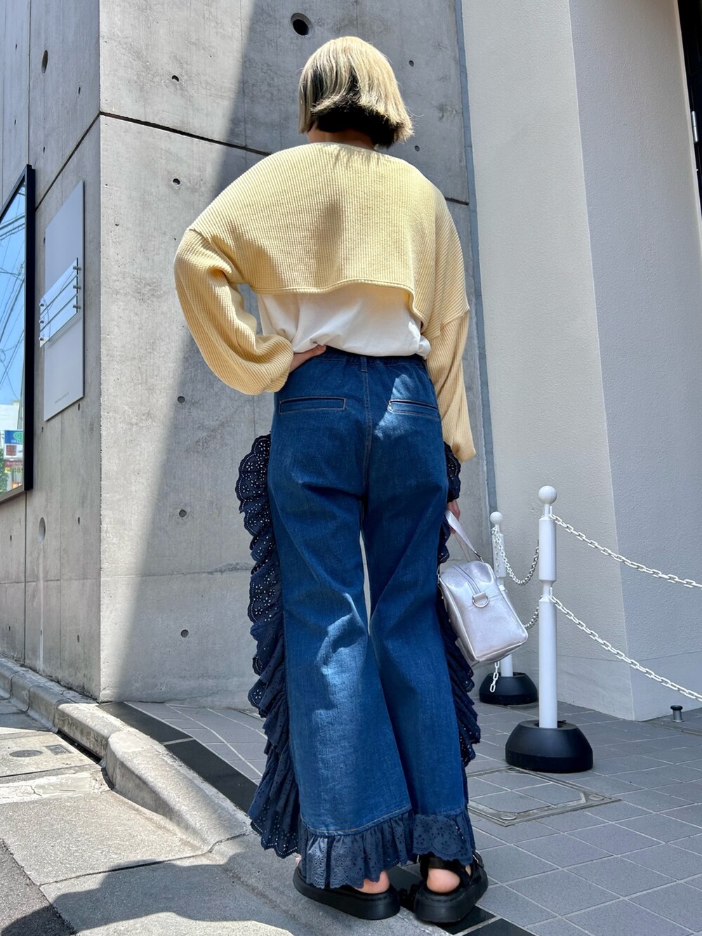イエロー系のカーディガン/ボレロ、ホワイト系のTシャツ/カットソー、シルバー系のボストンバッグを着用したレディースの夏コーディネートの4枚目の写真