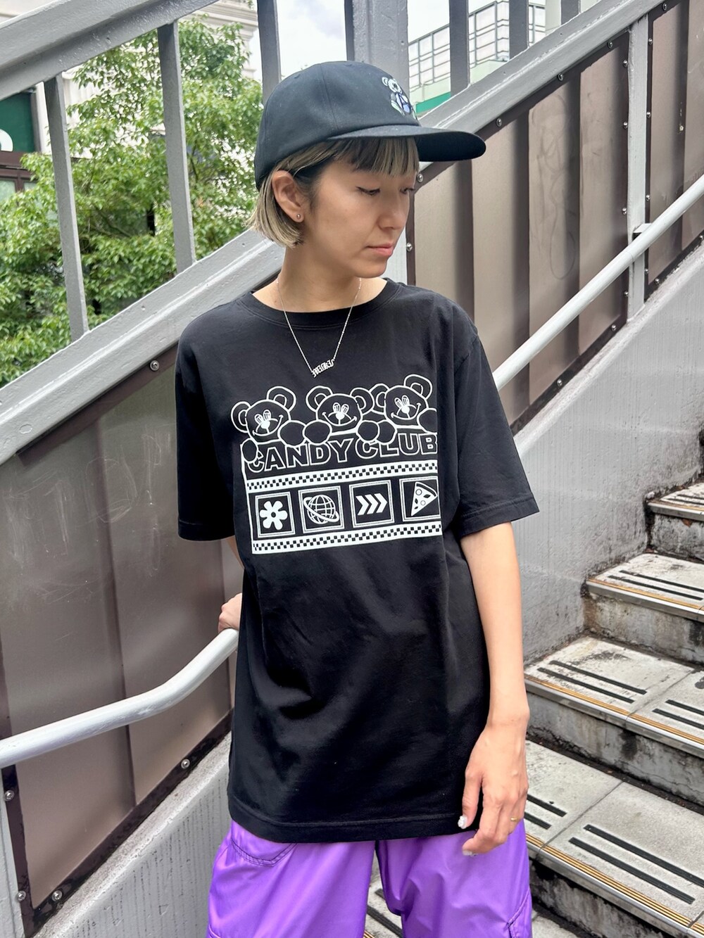 パープル系のカーゴパンツ、ブラック系のTシャツ/カットソー、ブラック系のキャップを着用したレディースの夏コーディネートの5枚目の写真