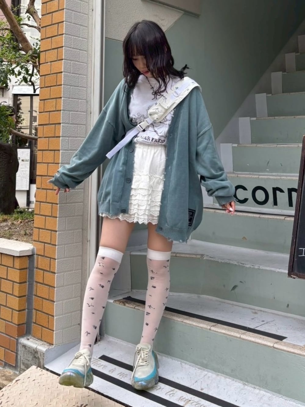 ホワイト系のTシャツ/カットソー、ブルー系のカーディガン/ボレロ、ホワイト系のスカートを着用したレディースの秋コーディネートの2枚目の写真