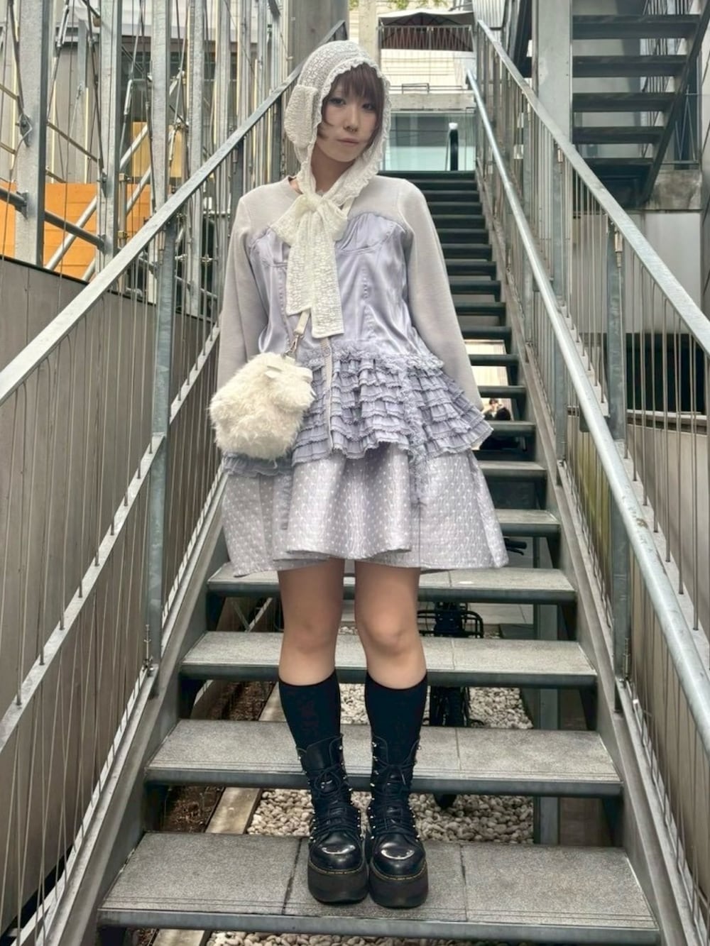 ホワイト系のショルダーバッグ、グレー系のワンピース、グレー系のカーディガン/ボレロを着用したレディースの秋コーディネートの3枚目の写真