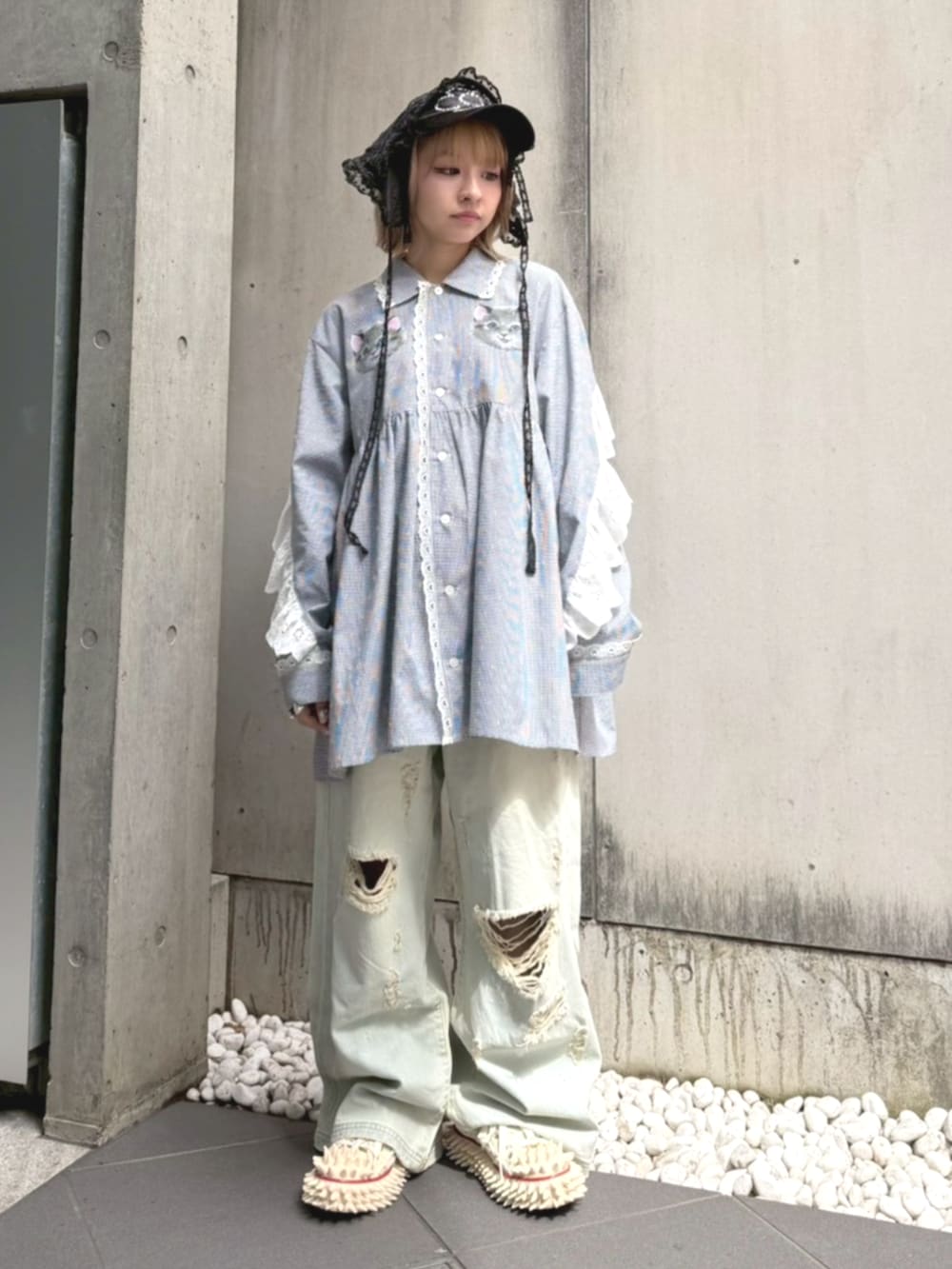 ブルー系のデニムパンツ、ブラック系のシャツワンピース、ブラック系のキャップを着用したレディースの春コーディネートの2枚目の写真