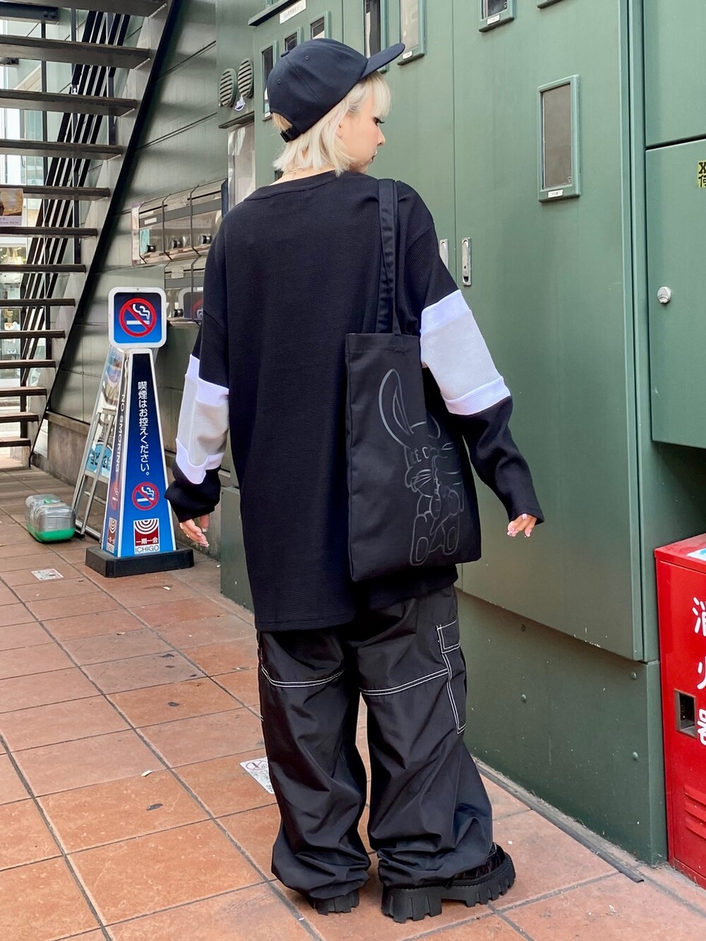 ブラック系のTシャツ/カットソー、ブラック系のカーゴパンツ、ブラック系のトートバッグを着用したレディースの夏コーディネートの4枚目の写真