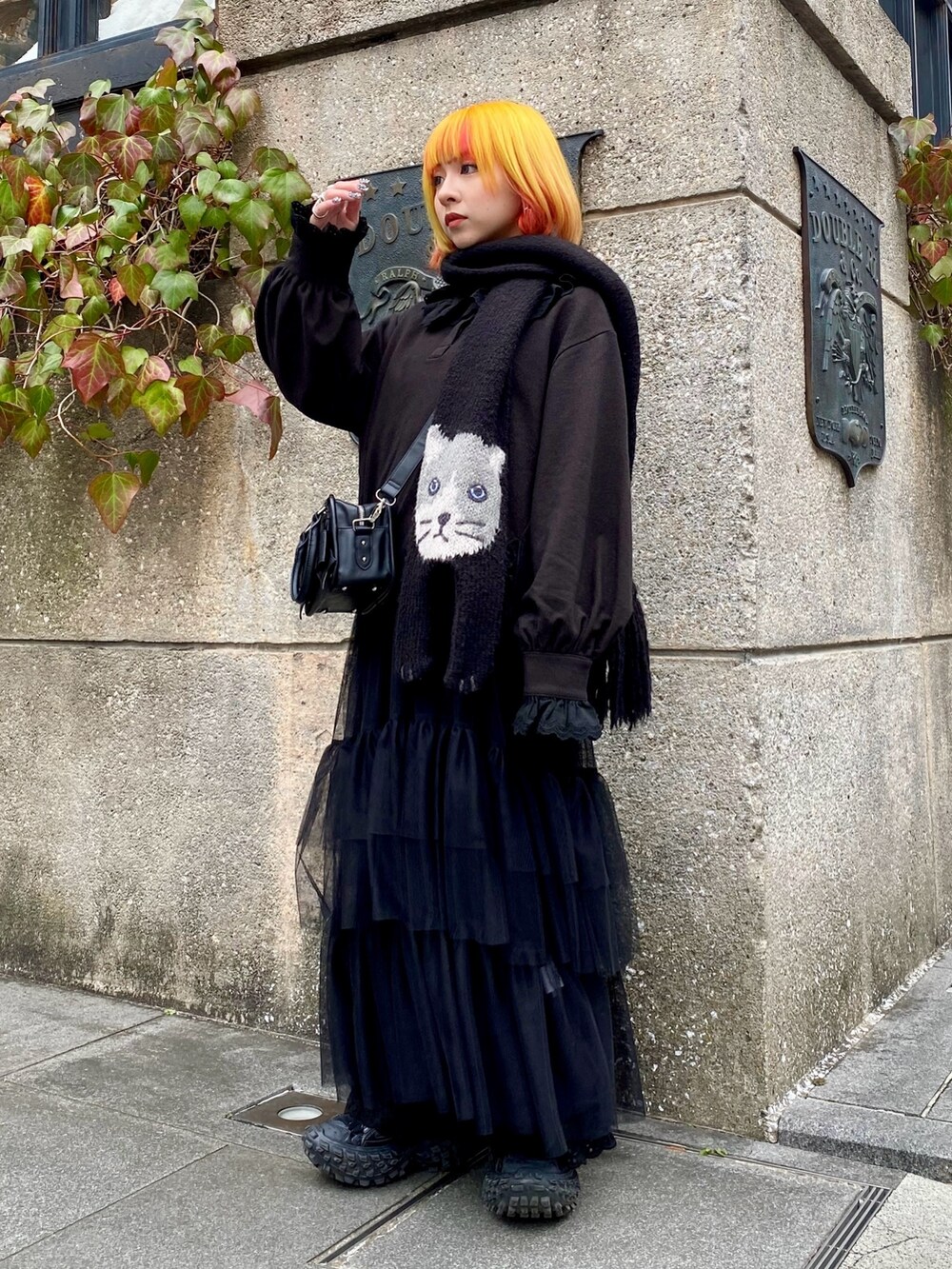 ブラック系のポロシャツ、ブラック系のワンピース、ブラック系のその他パンツを着用したレディースの冬コーディネートの2枚目の写真