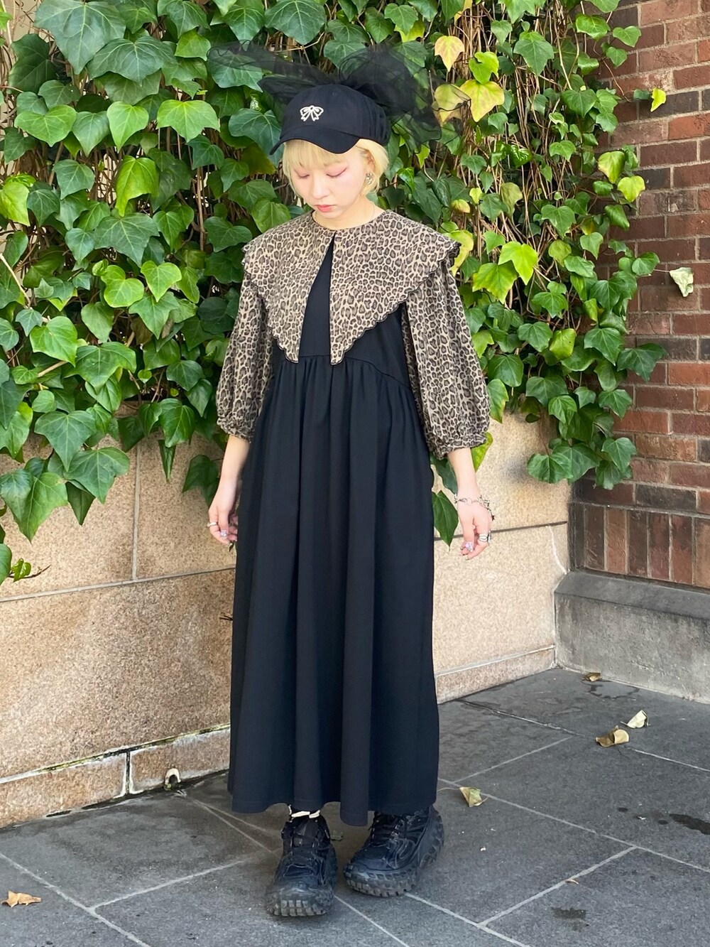 ブラック系のワンピース、ブラック系のキャップを着用したレディースの春コーディネートの3枚目の写真