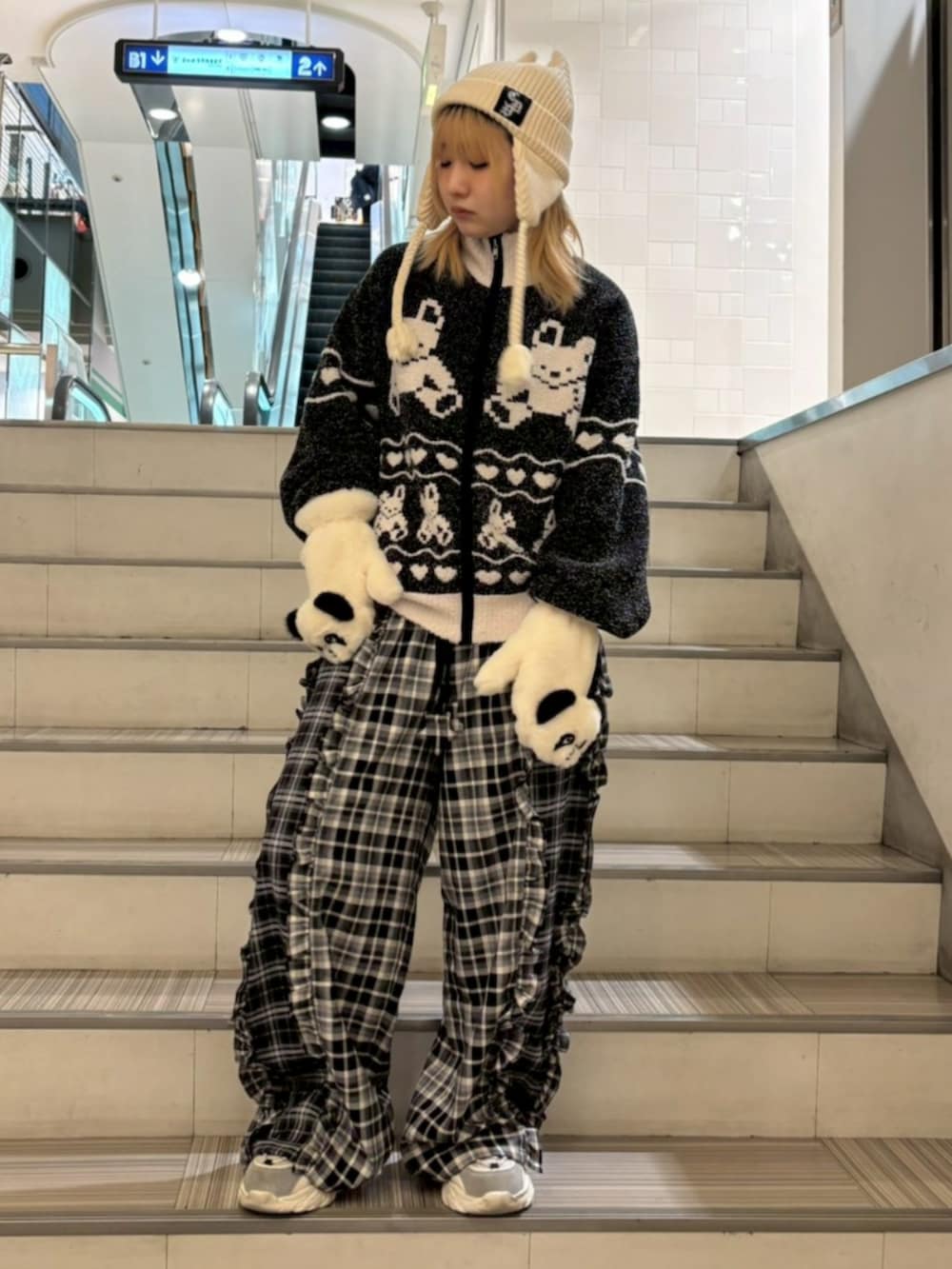 ブラック系のその他アウター、ブラック系のその他パンツ、ホワイト系のニットキャップ/ビーニーを着用したレディースの冬コーディネートの3枚目の写真