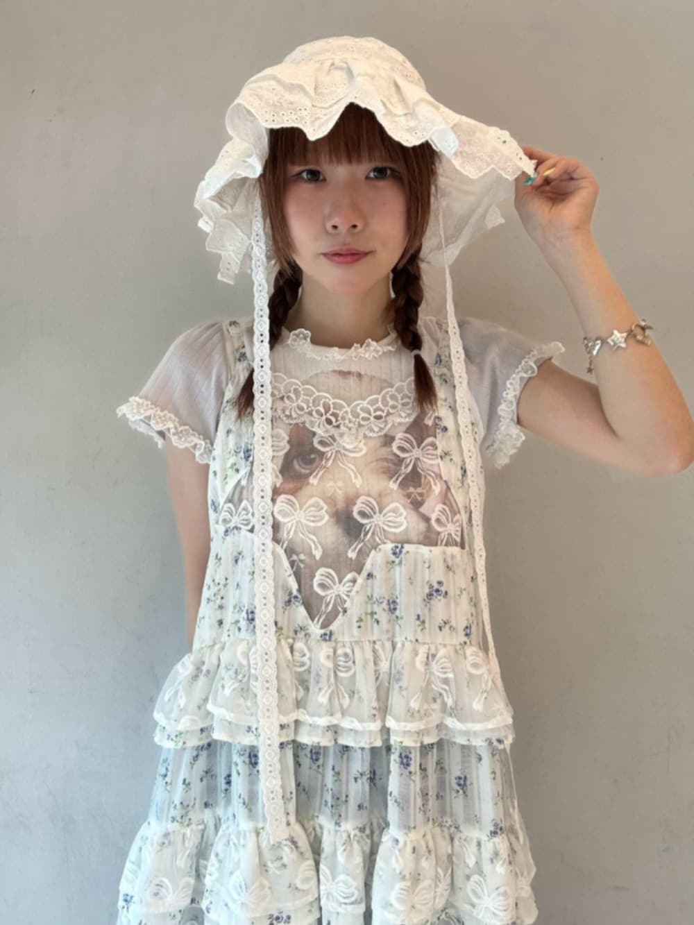 グレー系のTシャツ/カットソー、ブルー系のデニムパンツ、ホワイト系のワンピースを着用したレディースの秋コーディネートの3枚目の写真