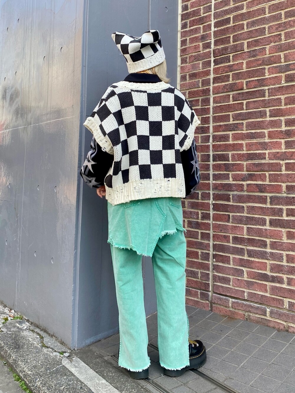 ブラック系のベスト、ブラック系のポロシャツ、グリーン系のその他パンツを着用したレディースの冬コーディネートの4枚目の写真