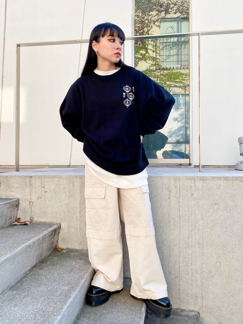 ブラック系のニット/セーター、ホワイト系のカーゴパンツを着用したレディースの秋コーディネートの2枚目の写真