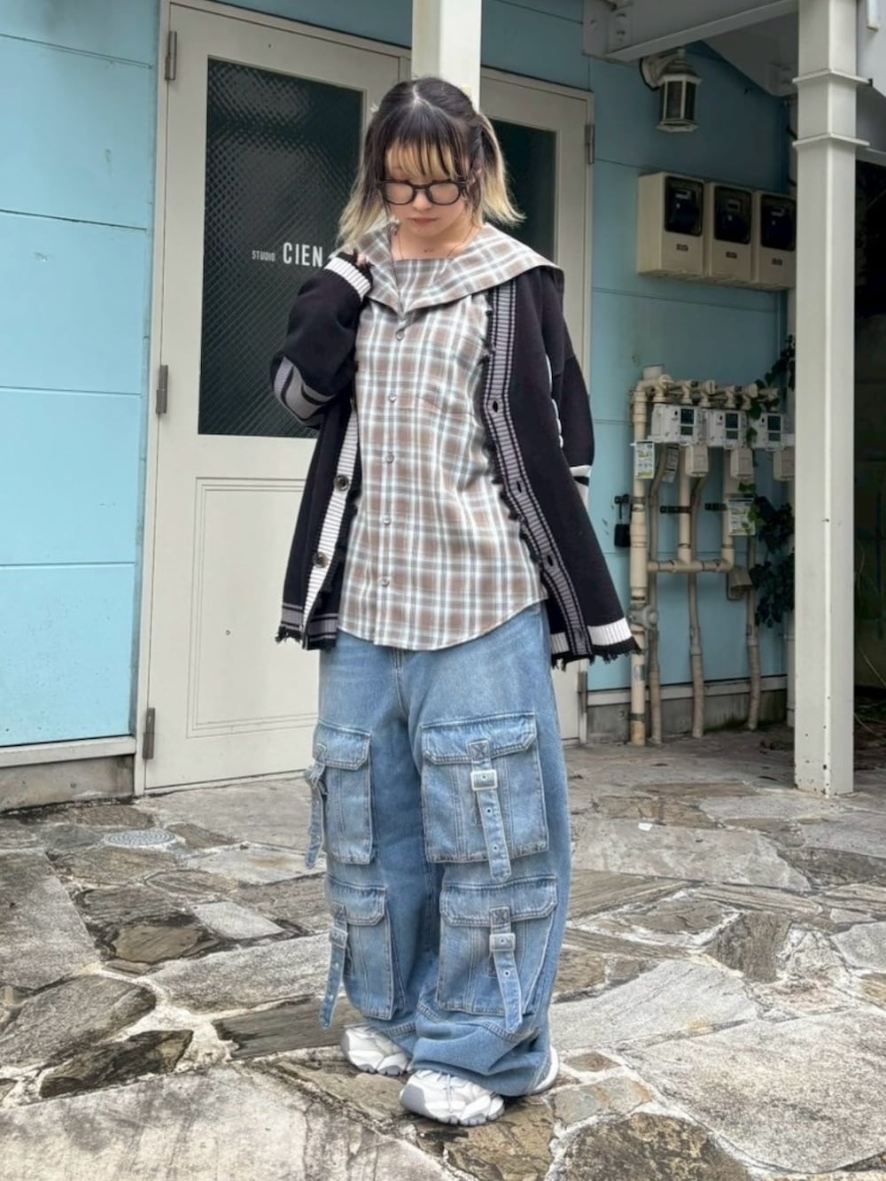 ブラウン系のシャツ/ブラウス、ブラック系のカーディガン/ボレロ、ブルー系のデニムパンツを着用したレディースの秋コーディネートの2枚目の写真