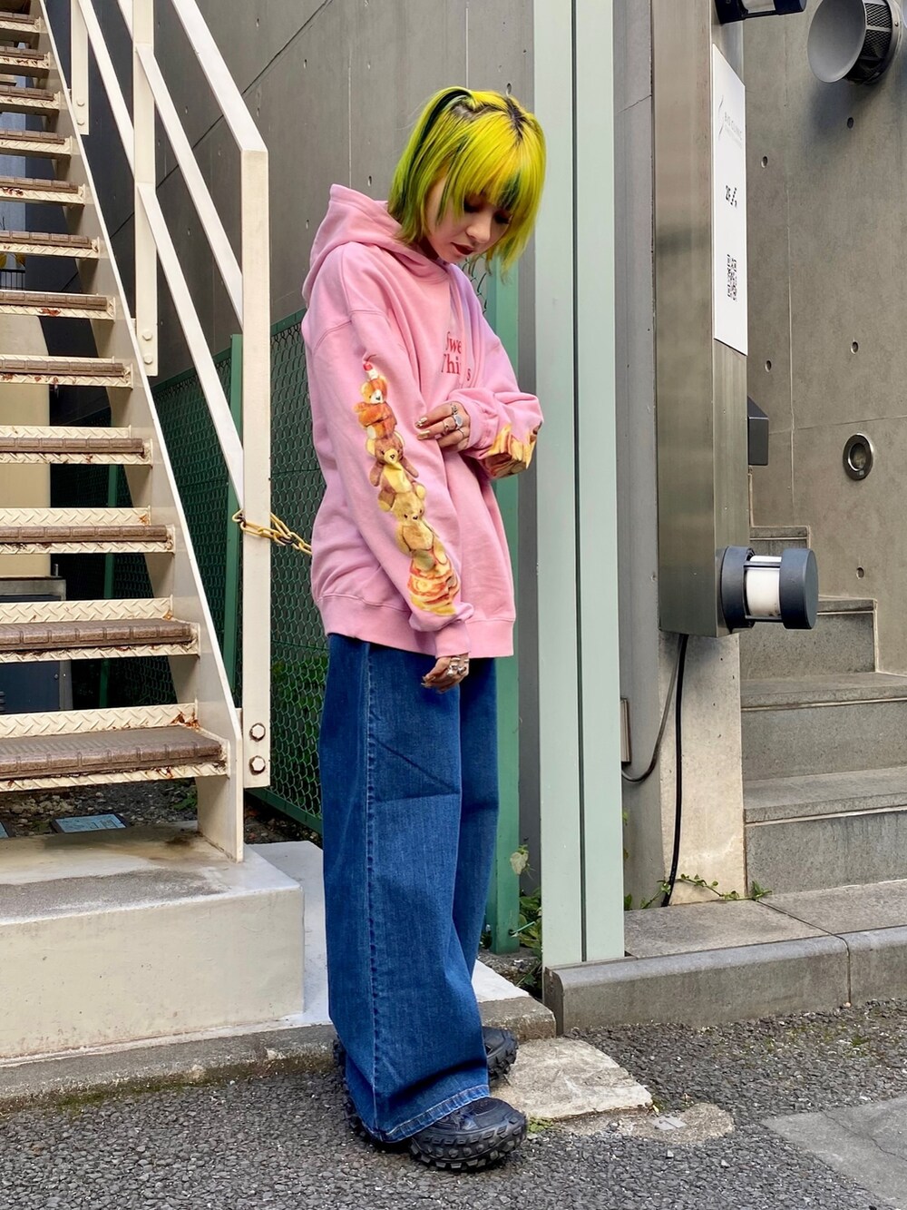 ピンク系のパーカー、ブルー系のデニムパンツ、ブラック系のMA-1を着用したレディースの冬コーディネートの4枚目の写真