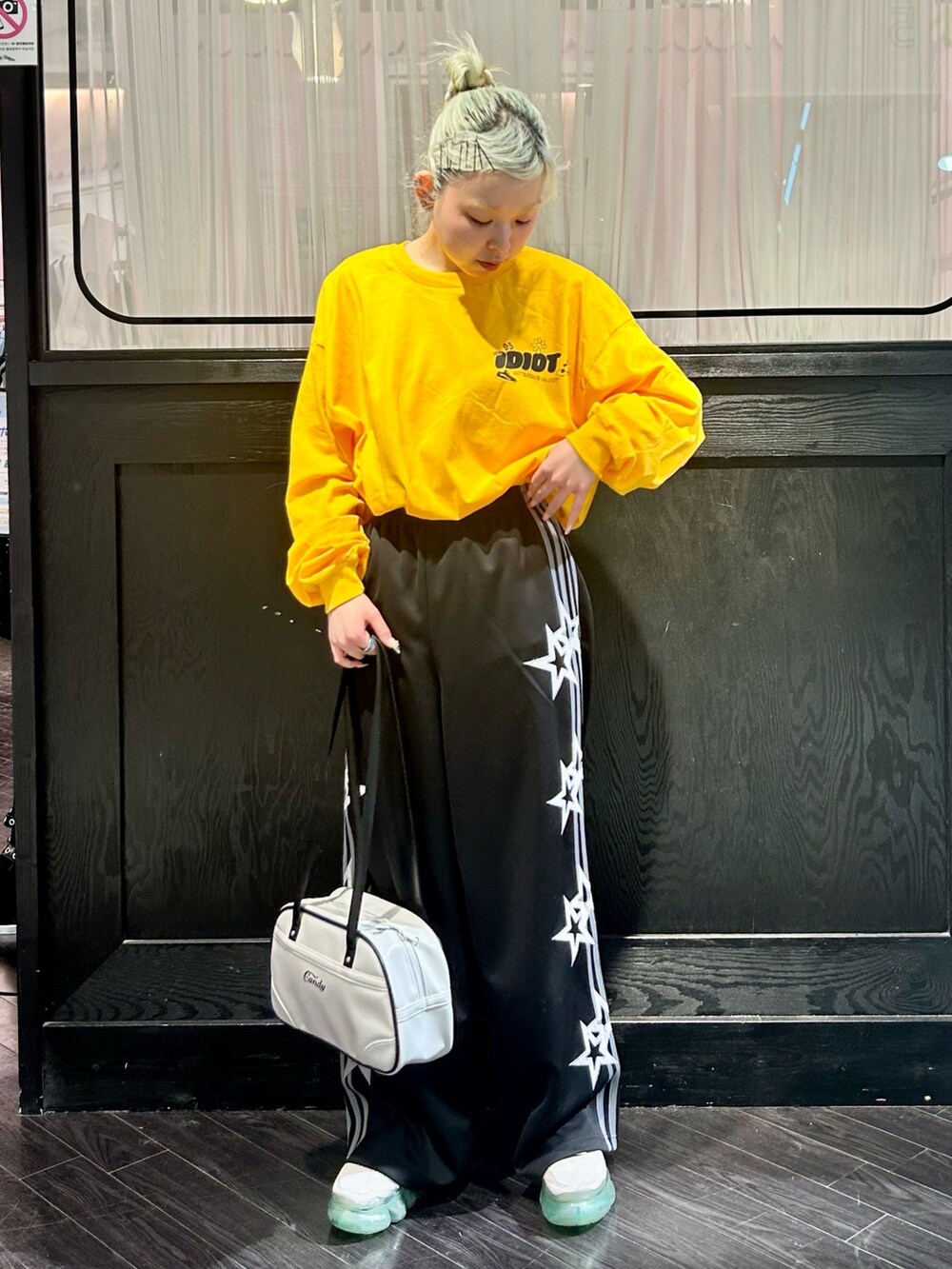 ブラック系のその他パンツ、イエロー系のTシャツ/カットソー、ホワイト系のボストンバッグを着用したレディースの冬コーディネートの2枚目の写真