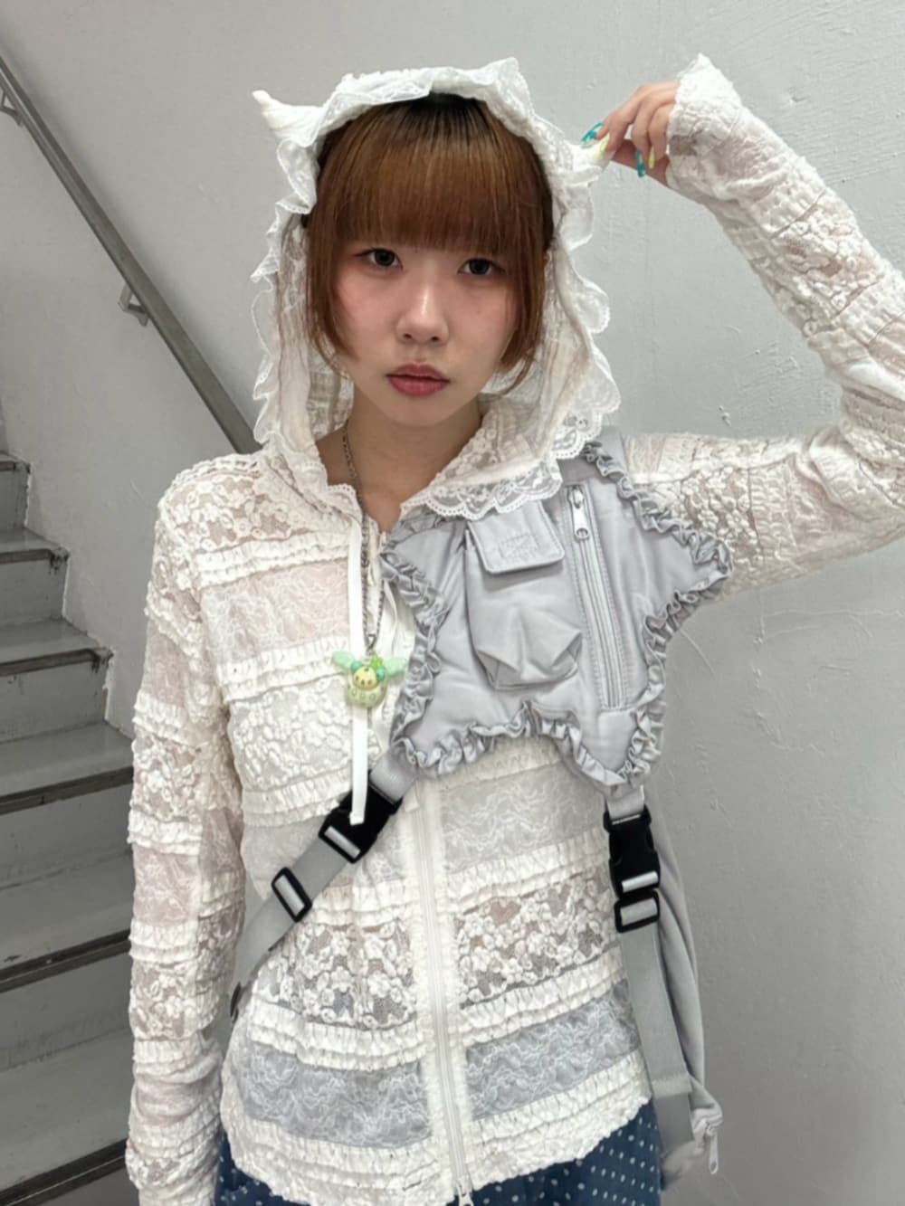 ブルー系のデニムパンツ、ホワイト系のパーカー、グレー系のショルダーバッグを着用したレディースの秋コーディネートの4枚目の写真