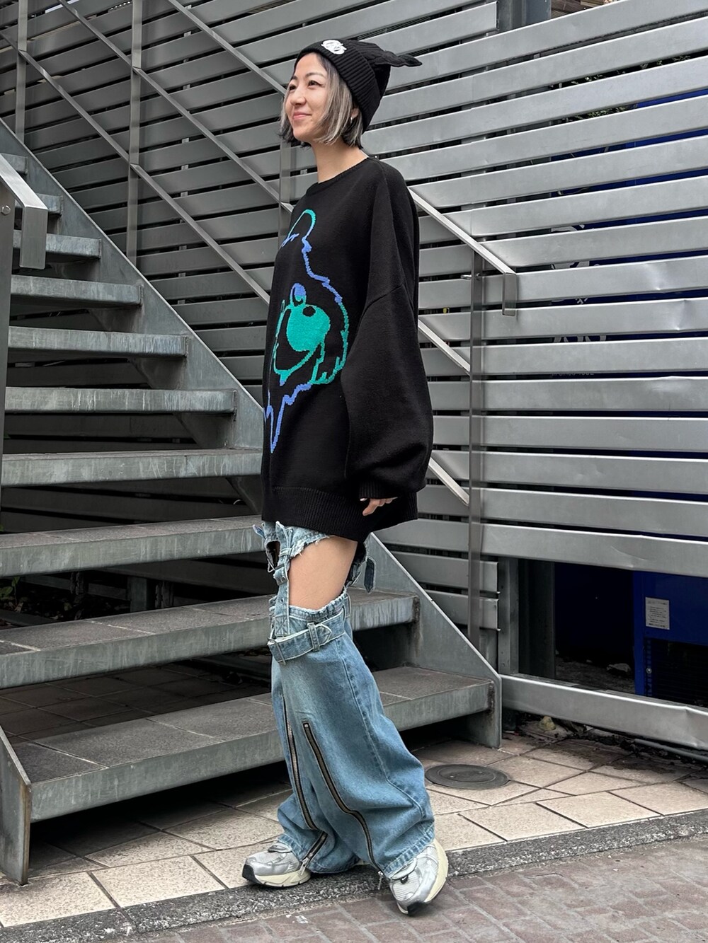 ブラック系のニット/セーター、ブルー系のデニムパンツ、シルバー系のシューズを着用したレディースの秋コーディネートの4枚目の写真