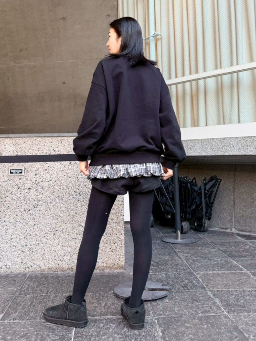 グレー系のスカート、ブラック系のスウェットを着用したレディースの冬コーディネートの3枚目の写真