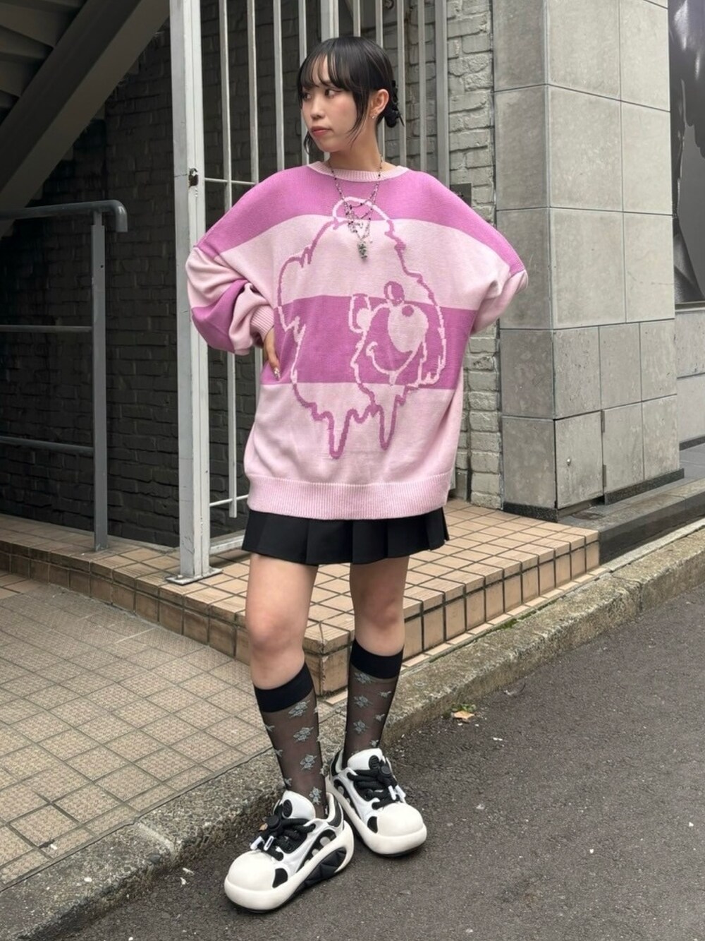 ブラック系のショルダーバッグ、ブラック系のスカート、ピンク系のニット/セーターを着用したレディースの秋コーディネートの5枚目の写真