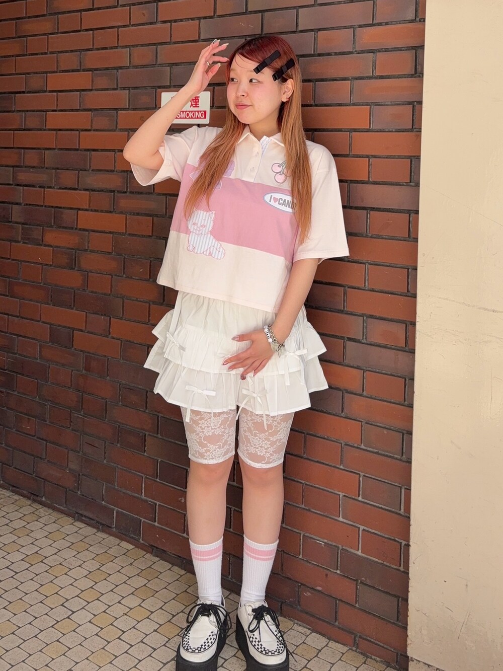 ピンク系のポロシャツ、ホワイト系のその他パンツを着用したレディースの夏コーディネートの3枚目の写真