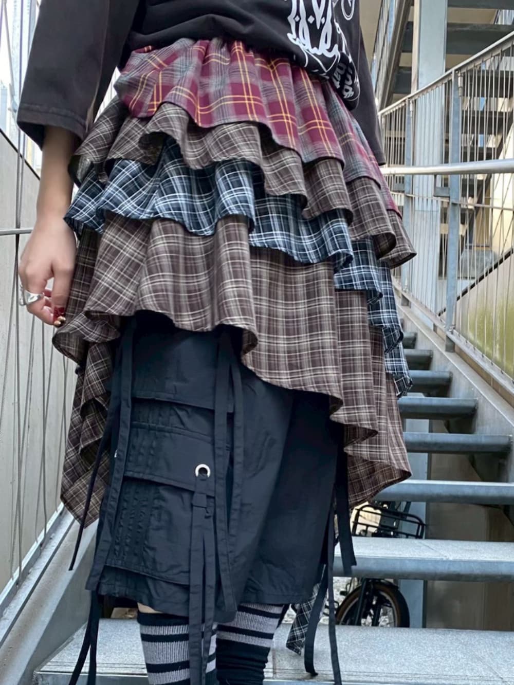 ブラック系のTシャツ/カットソー、レッド系のスカート、ブラック系のその他パンツを着用したレディースの春コーディネートの4枚目の写真