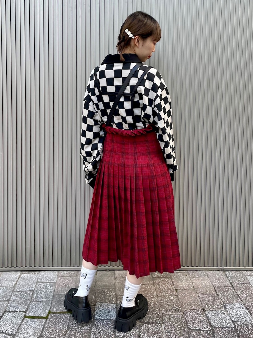 ベージュ系のポロシャツ、レッド系のスカート、ブラック系のショルダーバッグを着用したレディースの秋コーディネートの3枚目の写真