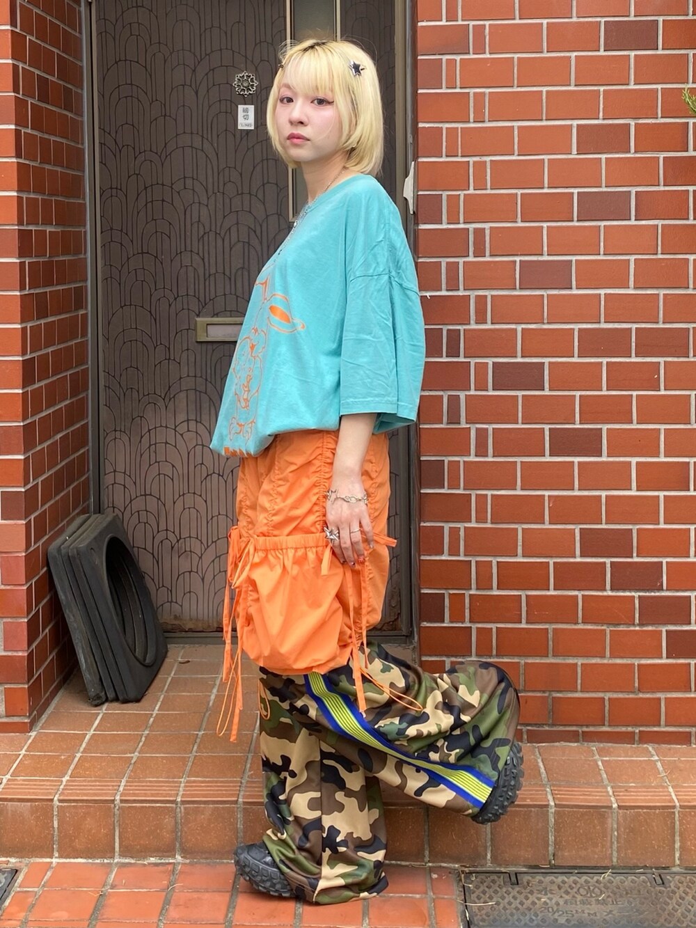 ベージュ系のその他パンツ、オレンジ系のその他パンツ、ホワイト系のTシャツ/カットソーを着用したレディースの春コーディネートの2枚目の写真