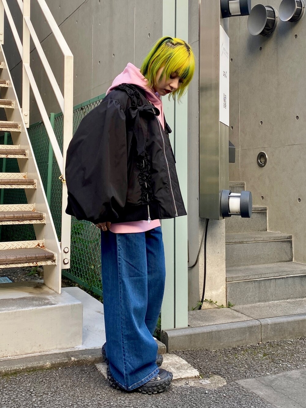 ピンク系のパーカー、ブルー系のデニムパンツ、ブラック系のMA-1を着用したレディースの冬コーディネートの2枚目の写真