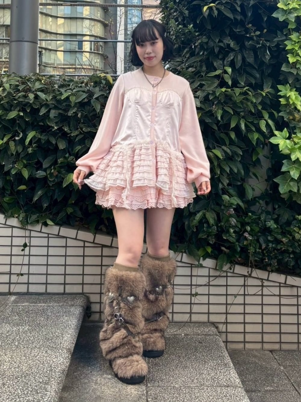 ブラウン系のブーツ、ピンク系のスカート、ピンク系のカーディガン/ボレロを着用したレディースの冬コーディネートの3枚目の写真