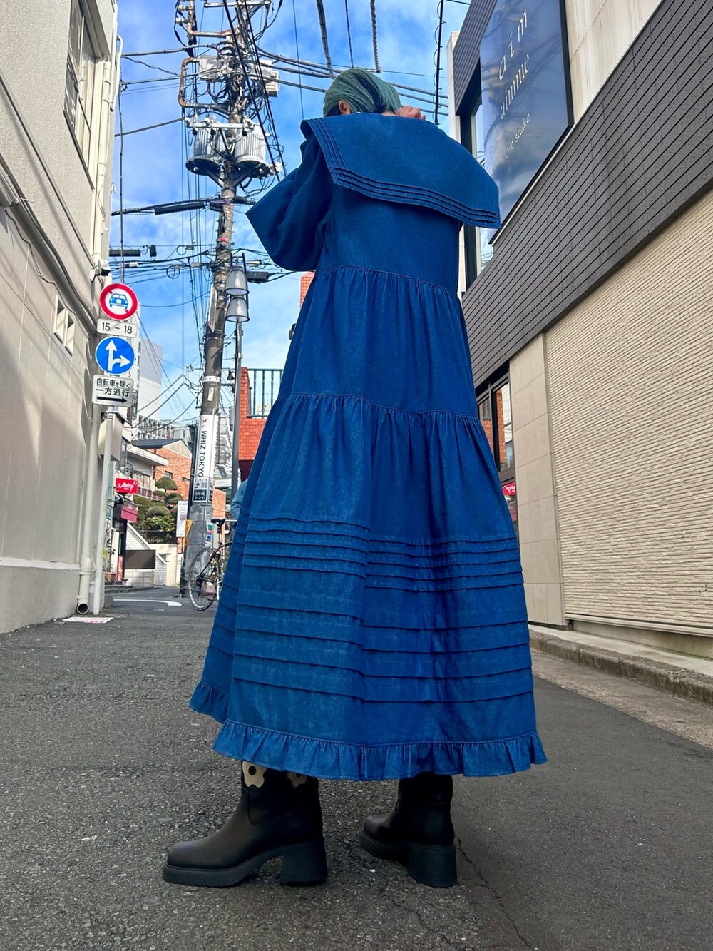 ブルー系のワンピース、ブラック系のブーツを着用したレディースの冬コーディネートの3枚目の写真