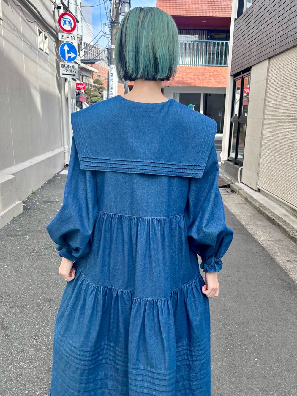 ブルー系のワンピース、ブラック系のブーツを着用したレディースの冬コーディネートの5枚目の写真