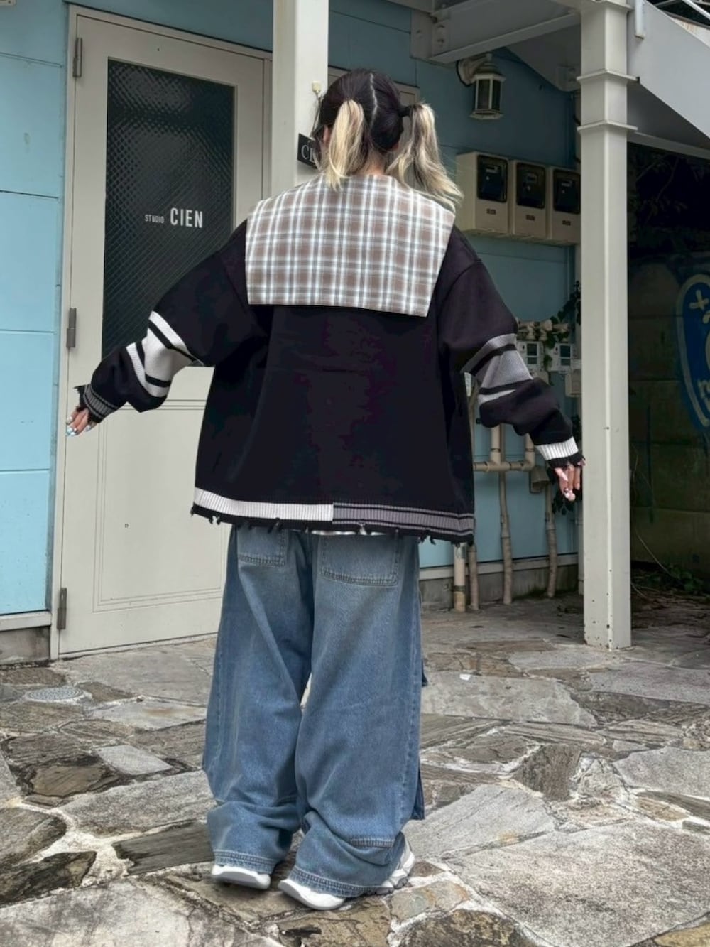 ブラウン系のシャツ/ブラウス、ブラック系のカーディガン/ボレロ、ブルー系のデニムパンツを着用したレディースの秋コーディネートの5枚目の写真