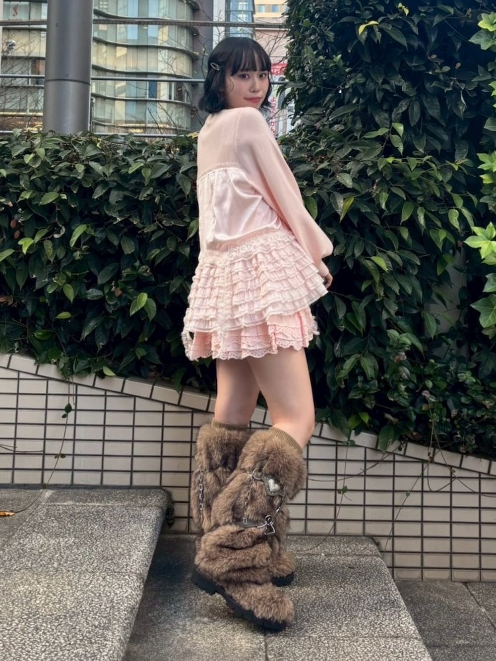 ブラウン系のブーツ、ピンク系のスカート、ピンク系のカーディガン/ボレロを着用したレディースの冬コーディネートの4枚目の写真