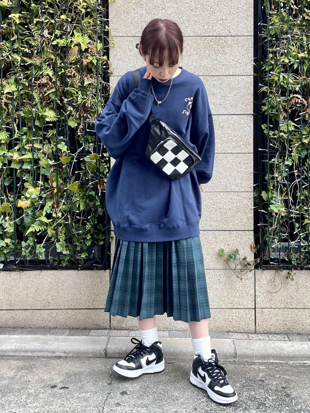 ブルー系のスウェット、グリーン系のスカート、ブラック系のボディバッグ/ウエストポーチを着用したレディースの冬コーディネートの3枚目の写真