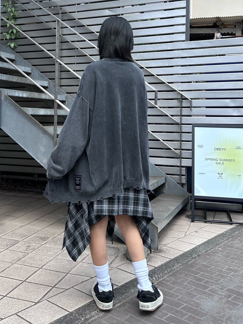 ブラック系のスカート、ブラック系のTシャツ/カットソー、グレー系のカーディガン/ボレロを着用したレディースの秋コーディネートの5枚目の写真