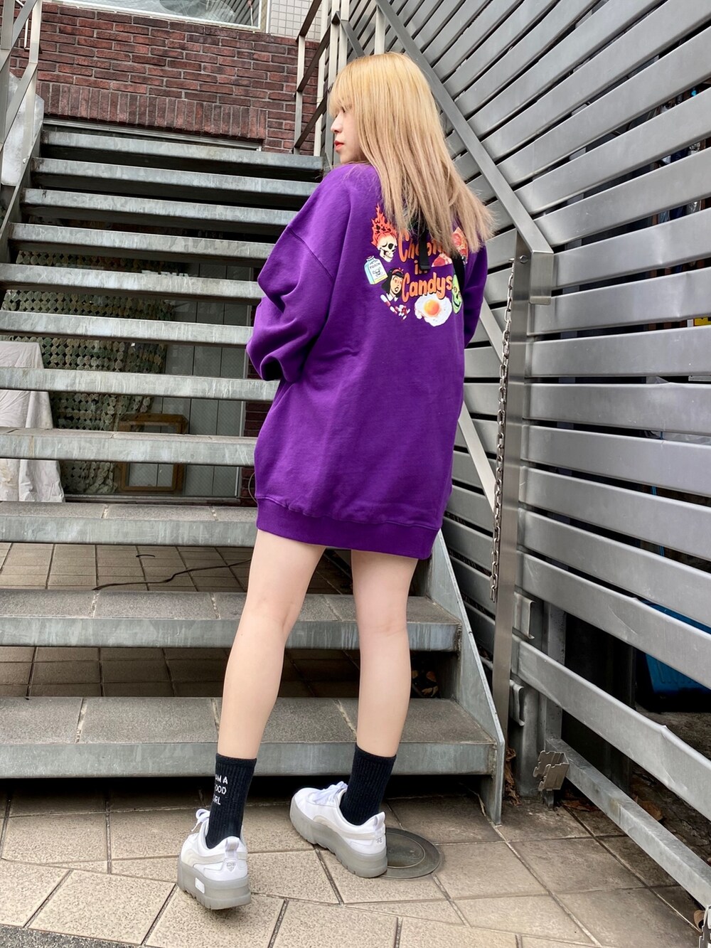 パープル系のスウェット、ブラック系のボディバッグ/ウエストポーチを着用したレディースの冬コーディネートの2枚目の写真