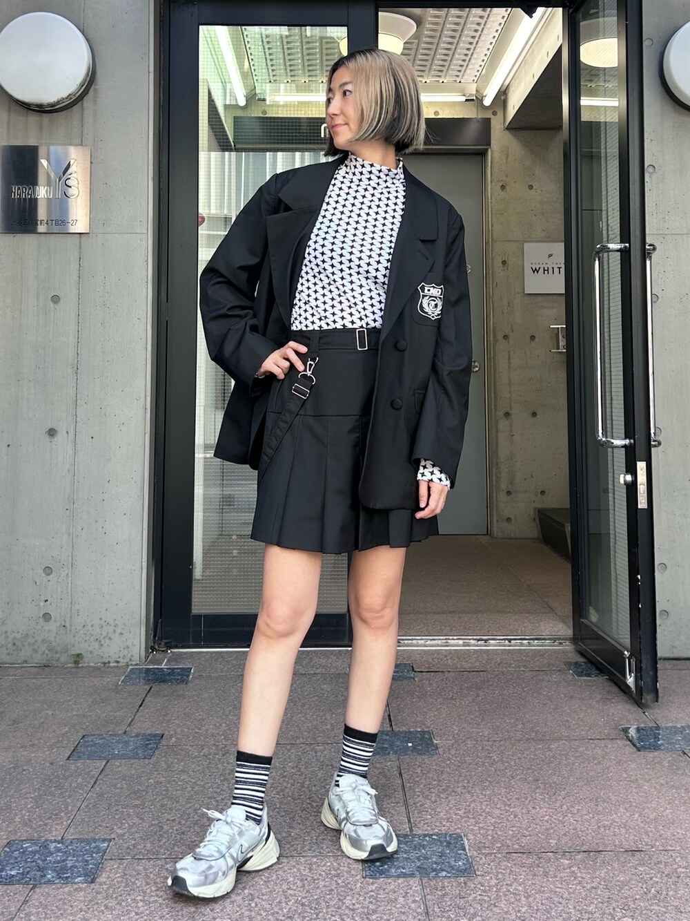 ブラック系のテーラードジャケット、ホワイト系のその他トップス、ブラック系のスカートを着用したレディースの秋コーディネートの3枚目の写真